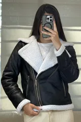 Campera tipo gamulán de cuero sintético negro con interior y solapas de corderito blanco. Presenta cierre frontal cruzado y bolsillos laterales con cierre.