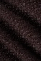 Pantalón amplio de punto bouclé color marrón oscuro, de tiro alto con elástico oculto en la cintura, bolsillos delanteros y cierre con botón.