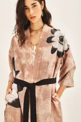 Kimono largo estampado con diseño floral, de corte recto y mangas amplias 3/4. Presenta un diseño de bloques de color con una base en tonos tierra y un borde inferior en color negro.