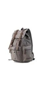 Mochila de tela canvas color marrón con detalles en cuero sintético. Cuenta con tapa superior con correas ajustables, cierre tipo marinero, múltiples bolsillos externos con cierre y compartimento para laptop.