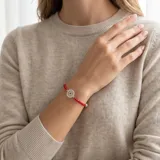 Pulsera de cuentas de cristal rojo con dije central circular de plata 925 calada y detalle de perla en el cierre.