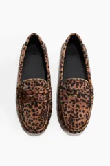 Mocasines tipo penny con pelo sintético estampado de leopardo. Presentan costura tradicional en el empeine y forro interior de sarga de algodón.