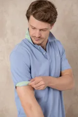 Remera azul marino de piqué de algodón, corte clásico, cuello polo con dos botones y logo de ave bordado en celeste en el pecho.