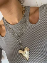 Collar plateado con cadena de eslabones grandes y dije de corazón.
