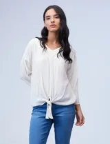 Blusa texturada color blanco, con escote en V con bordado, manga larga de largo regulable y ruedo con nudo.