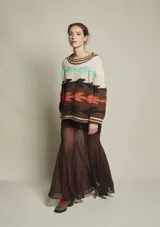 Sweater de lana tejido a mano con diseño abstracto en tonos beige, marrón, naranja, celeste y negro. De calce holgado, con cuello redondo y puños acanalados.