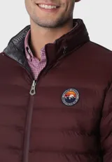 Campera acolchada reversible color bordó con interior gris, cierre frontal con cremallera, cuello alto y logo bordado en el pecho.