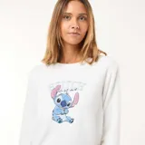 Conjunto de pijama de dos piezas confeccionado en tela polar suave. Incluye una remera de manga larga color blanco con estampa central de Stitch y un pantalón largo color gris claro con estampado integral de Stitch.
