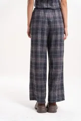 Pantalón de corte amplio y tiro medio con estampado a cuadros en tonos grises y detalles en naranja. Presenta cintura elastizada con cordón de ajuste frontal y diseño de pierna recta.