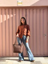 Cartera shopper de cuero color marrón chocolate, con doble asa de hombro, bolsillo frontal externo y diseño estructurado.