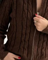 Sweater tipo campera de punto color blanco marfil, con cierre frontal completo y cuello alto.