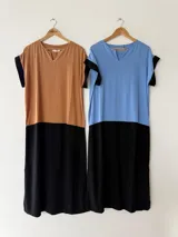 Vestido largo oversize en combinación de colores tostado y negro, con escote en V, mangas cortas y bolsillos laterales.