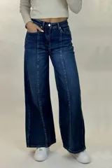 Pantalón de jean estilo wide leg con costuras verticales decorativas en el frente, tiro alto y cierre frontal con botón y cremallera.