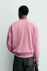Sudadera regular fit color azul, de cuello redondo, manga larga ranglán y efecto lavado con acabados en rib.