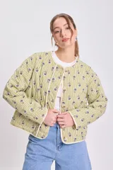 Cazadora capitoneada de corte recto, con diseño de rayas verticales verdes y estampado floral. Presenta cuello redondo, cierre frontal con botones y bolsillos laterales de parche.