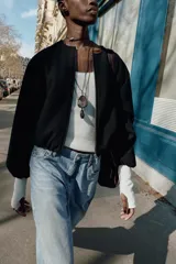 Chaqueta bomber de cuello redondo y manga larga con diseño holgado. Presenta cierre frontal con cremallera, bolsillos delanteros de vivo y acabados elásticos en los puños y el ruedo.