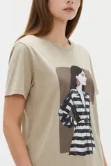 Remera de algodón color negro, con cuello redondo, mangas cortas y estampa frontal de diseño artístico con flores y figura humana.