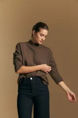 Polera de tejido de punto color blanco, con cuello alto acanalado, hombros caídos y detalle de costura vertical en el frente.
