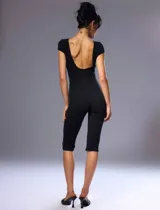 Mono capri negro de manga corta, con escote cerrado redondo al frente y espalda descubierta, confeccionado en tejido elástico.
