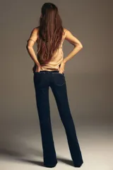 Jean de tiro alto con corte acampanado desde la rodilla, confeccionado en denim azul oscuro con costuras en contraste y diseño de cinco bolsillos.