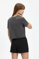 Remera cropped de algodón gris oscuro, con cuello redondo, manga corta y estampa frontal de conejo con estrellas.