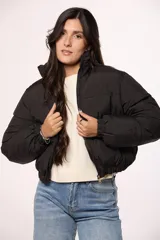 Campera bomber de nylon color negro, con cuello alto, cierre frontal y puños elásticos.