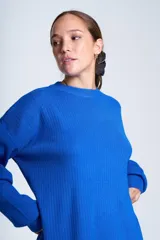 Sweater azul eléctrico de punto acanalado, con cuello redondo y mangas largas. Corte holgado con aberturas laterales.