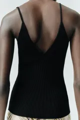 Top negro de punto con escote en pico y tirantes finos.