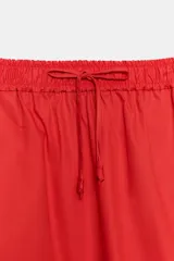 Falda midi de tiro medio confeccionada en algodón, con cintura elástica ajustable mediante cordones y bajo recto.