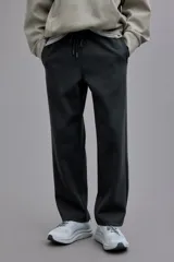 Pantalón de jogging negro de corte estándar, confeccionado en tejido de punto pesado. Presenta cintura elástica con cordón ajustable, bolsillos laterales y diseño de piernas rectas.