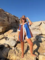 Camisola playera abierta de manga corta, con diseño en bloques de color azul y marrón, con solapas y ribetes blancos.