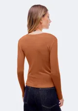 Camiseta de manga larga en color tostado, confeccionada en tejido de punto suave con cuello redondo y diseño ajustado.