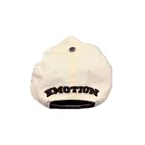 Gorro con visera de color beige y visera negra, con bordado frontal en relieve rojo y detalles de strass distribuidos por toda la prenda.