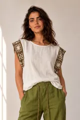 Blusa de lino color beige sin mangas, con cuello redondo y detalles de crochet en los hombros.