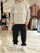 Canguro oversize gris con capucha y gran estampado gráfico trasero en tono más oscuro.