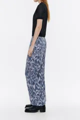Pantalón de viscosa con estampado animal print, corte recto, largo tobillero, cierre frontal con cremallera de plástico, bolsillos falsos con tapetas laterales y cintura con elástico interior.