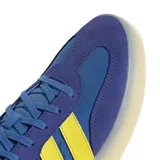 Championes urbanos Adidas modelo Barreda Decode, con diseño inspirado en el calzado de fútbol retro. Presentan una combinación de colores azul y violeta con las icónicas tres tiras en amarillo. Cuentan con puntera en forma de T, refuerzos de gamuza y una suela de goma translúcida.