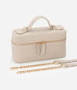 Cartera femenina tipo baú pequeña color beige, con textura tressê, correa de mano fija, cierre por cremallera y asa larga desmontable.
