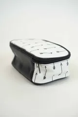 Neceser blanco con estampado de flechas negras, cierre de cremallera y asa superior de cuero sintético negro.