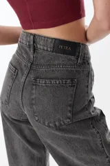 Pantalón de pierna ancha con acabado brillante, confeccionado en lino. Presenta un diseño de tiro medio con cierre de botón y cremallera, bolsillos traseros y etiqueta de marca en la cintura.