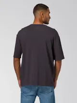 Remera de manga corta color negro lavado, con cuello redondo y logo de la marca Caterpillar estampado sutilmente en el pecho. Presenta un corte relajado y tejido de punto slub.