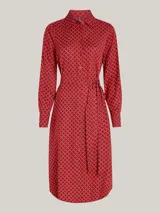 Vestido camisero midi rojo con estampado geométrico blanco, cuello camisero, manga larga con puños abotonados, cinturón anudable y abertura frontal.