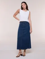 Falda maxi de denim azul, de tiro alto con pretina anatómica, pasacintos, cierre frontal con cremallera y botón metálico. Cuenta con diseño de cinco bolsillos, costura vertical central y corte recto de caída fluida al tobillo.