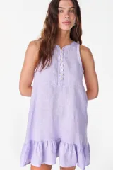 Vestido corto lila de lino, sin mangas, con escote redondo, cartera de botones de nácar en el frente y volado fruncido en el ruedo.