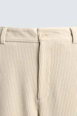 Pantalón de corte wide fit confeccionado en pana de algodón color marrón oscuro. Presenta bolsillos frontales, bolsillos traseros de vivo con botón y cierre frontal con cremallera y botón.