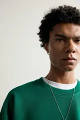 Sudadera de corte regular fit en color verde, con cuello redondo, manga larga raglán y acabados en rib elástico en cuello, puños y dobladillo.