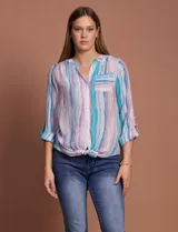 Blusa de gasa con estampado de rayas verticales en tonos celestes, violetas y blancos. Presenta cuello mao con escote en V, cierre frontal con botones, bolsillo aplicado en el pecho y mangas largas con presilla para regular el largo. El diseño incluye un nudo en la parte inferior delantera.