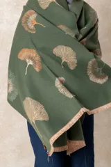 Pashmina reversible de textura suave y caída fluida, con diseño estampado de hojas de ginkgo biloba. Presenta un lado con fondo oscuro y otro con fondo claro, finalizando en ambos extremos con flecos cortos deshilachados.