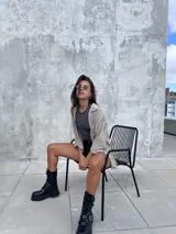 Camisa oversize de textura ligera y efecto nevado, con cuello clásico, cierre frontal de botones y mangas largas con detalle de frunces en los hombros.