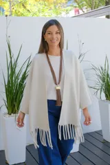 Saco abierto de corte recto y holgado, color visón, con mangas tres cuartos y detalle de flecos largos en el ruedo.